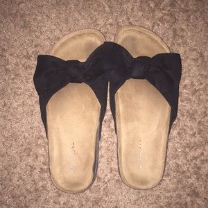 Women’s sandal with black bow.